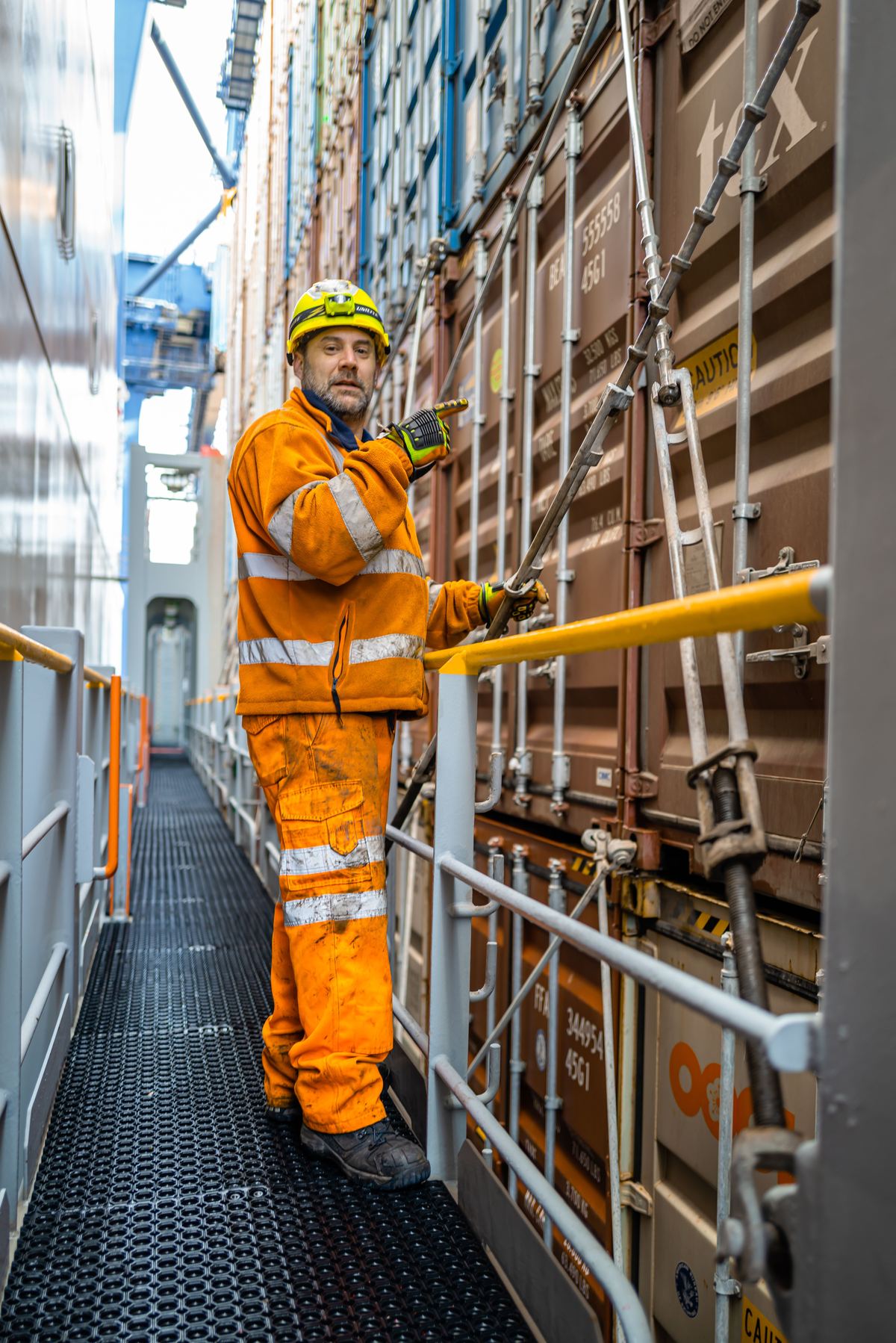 Crew member securing container lashings on a vessel